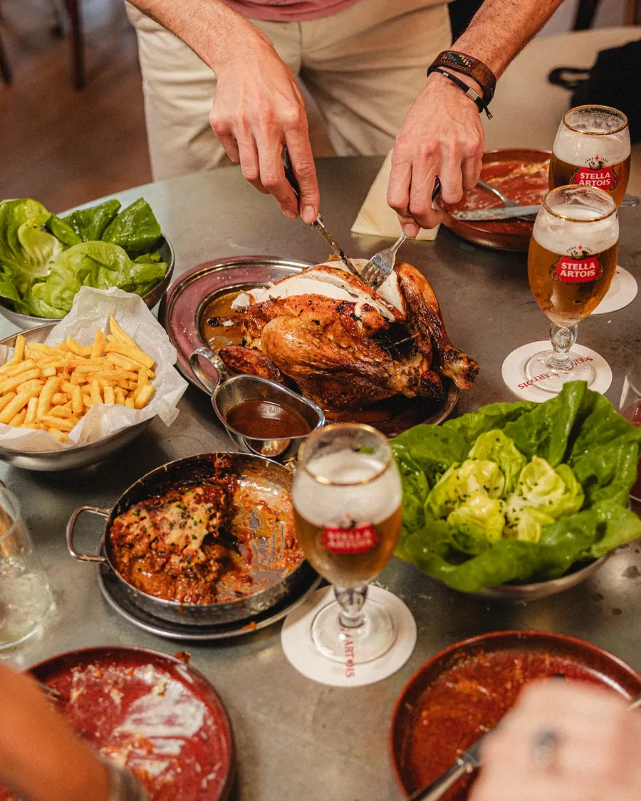 A whole roast chicken carved at the table
